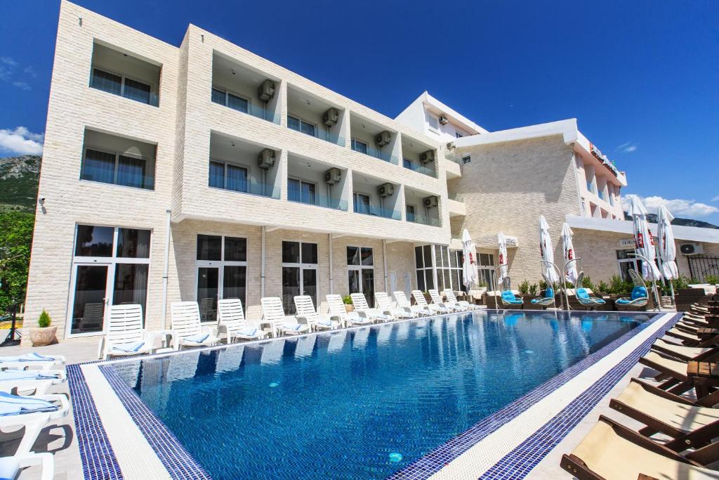a hotel with a swimming pool and lounge chairs at Sutomore Akapulco Hotel in Sutomore