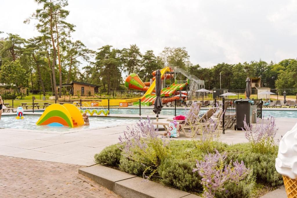 a pool with a water park with a water slide at Vakantiepark Ommerland in Ommen
