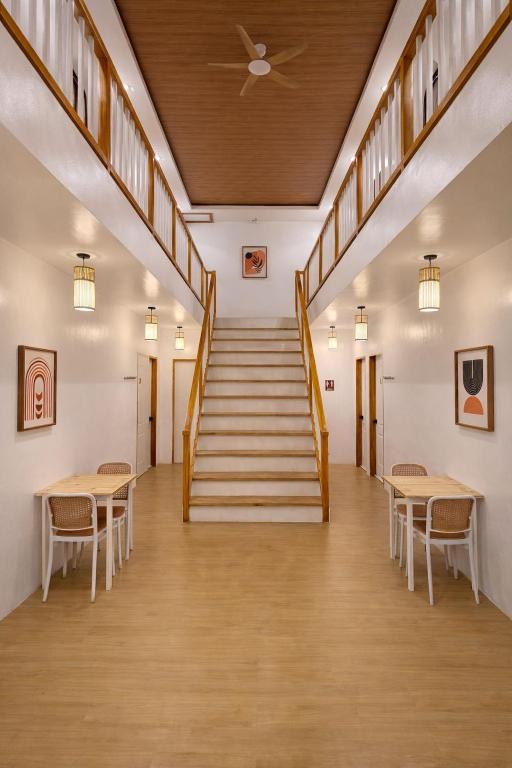 a staircase in a building with tables and chairs at AMIGOS Hostel El Nido in El Nido