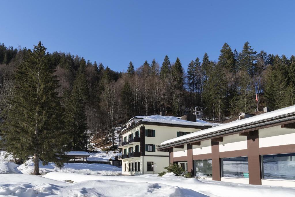 a building in the snow with trees in the background at Hotel Bad Serneus in Klosters