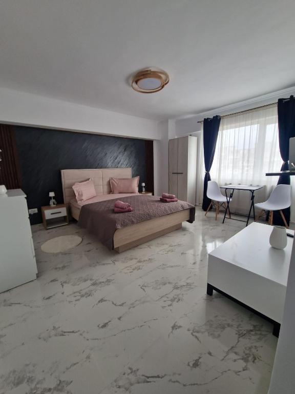 a bedroom with a large bed and a table at Little Escape in Brăila