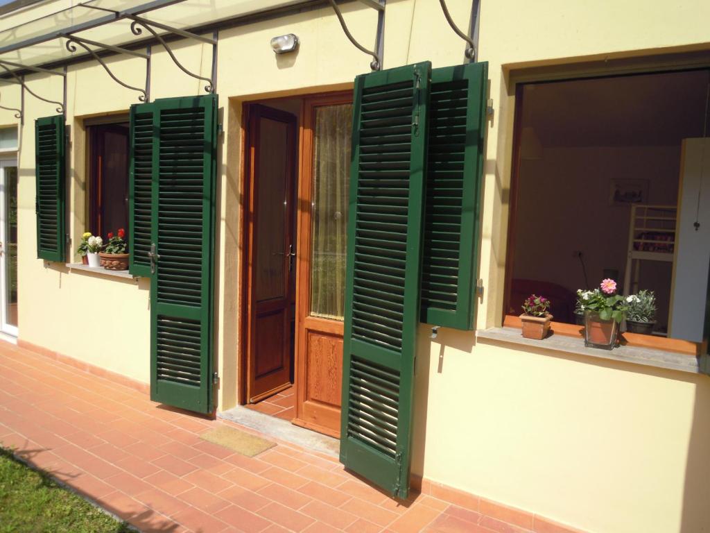 una casa con persianas verdes y una ventana en Geoglobe Chambre d'Hòtes, en Pisa