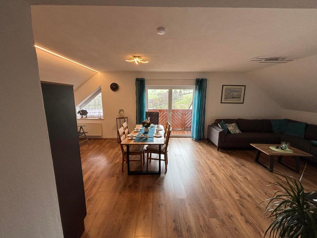 a living room with a table and a couch at Ferienwohnung Lodge 13 in Ehrenberg
