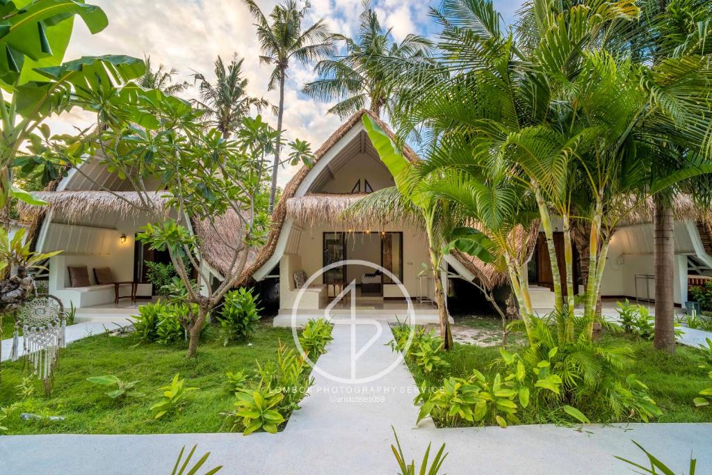 a house on the beach with palm trees at Ings Garden Acommodation in Gili Islands