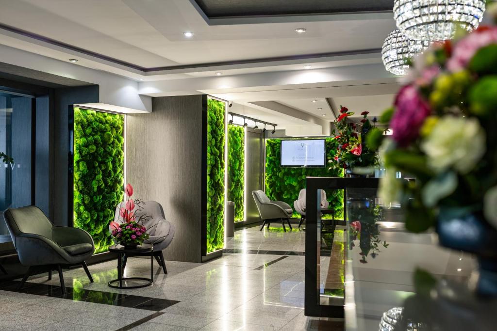 a waiting room with chairs and plants on the walls at Aparthotel Vanilla in Krakow