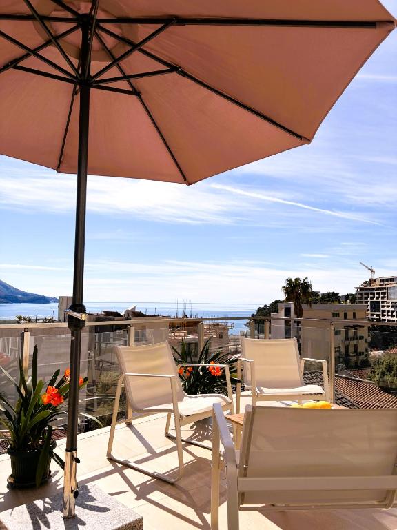 a patio with chairs and an umbrella on a roof at Apartments Marina in Bečići