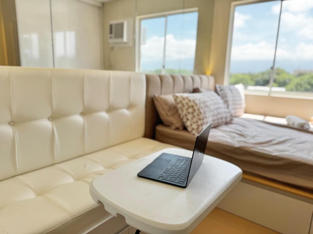 a laptop sitting on a coffee table in a living room at Bears Nook - Marina Spatial Dumaguete in Piapi