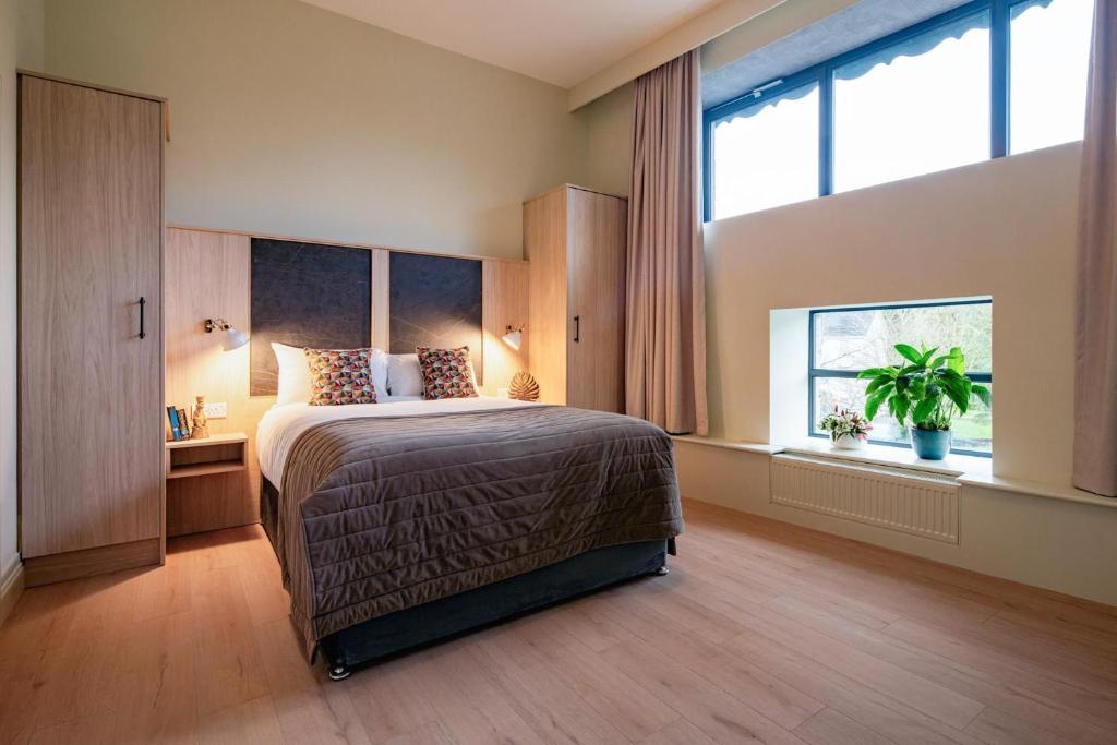 a bedroom with a bed and a large window at The Malt Store in Birr