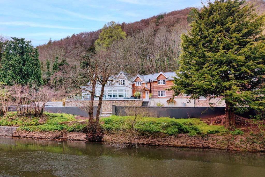a large house on the side of a river at Finest Retreats - Alpine Cottage in Symonds Yat