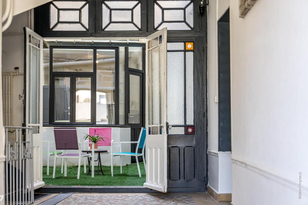 an open door to a room with chairs and a table at Maison au cœur de Saumur Cour privée Parking gratuit Wi-Fi in Saumur