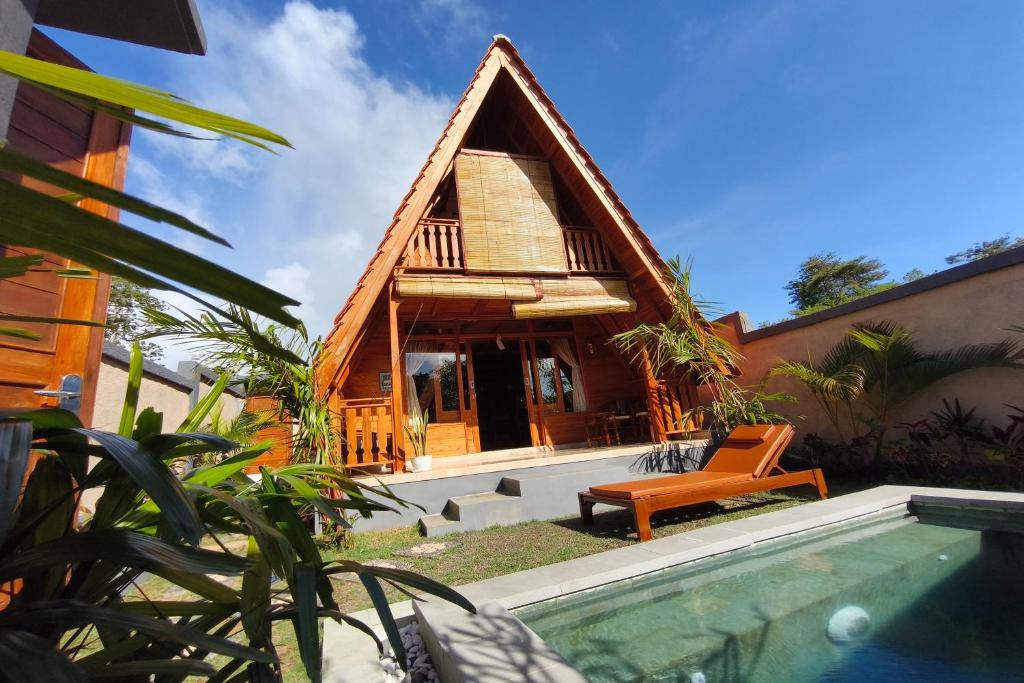 a house with a pool in front of a house at D'Cabin Villa Uluwatu in Uluwatu