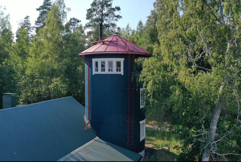 a blue house with a red roof on top of a house at Biskopsdal in Karuna