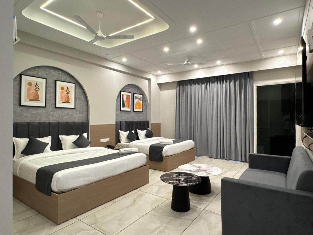 a hotel room with two beds and a couch at Hotel The Merc in Kharar