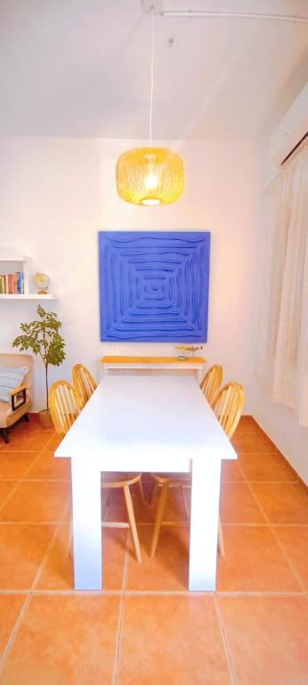 a white table with chairs and a blue wall at Casa Playa Moncofa in Moncófar