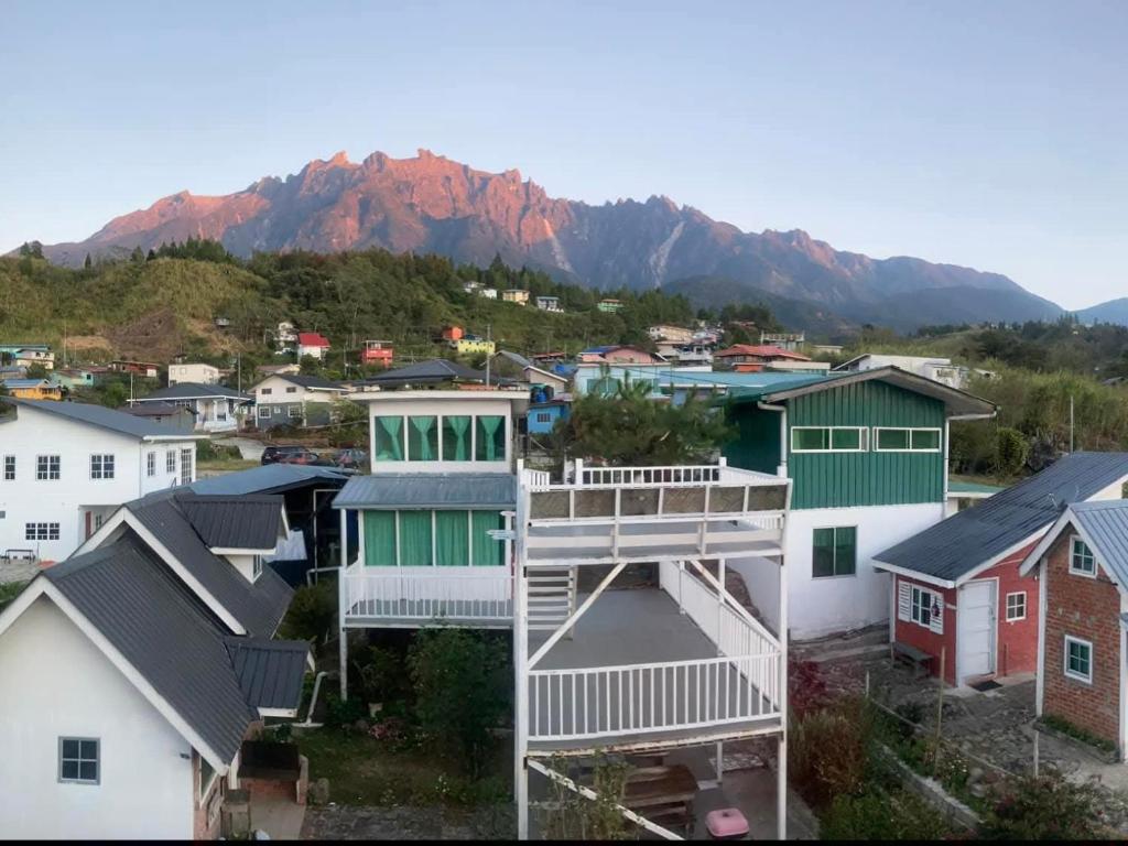 a group of houses with mountains in the background at Little hut in Kampong Kundassan