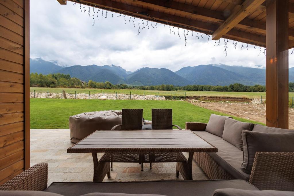 a patio with a table and couches and a view at Villa Eliyas near the Pirin Golf Resort in Razlog