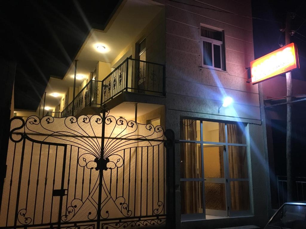 um edifício com um portão de ferro forjado à noite em Cheers Bed & Breakfast em Addis Ababa