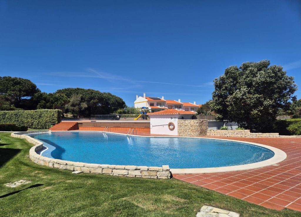 a swimming pool in a yard with a house in the background at Casa Arreyal in Amoreira