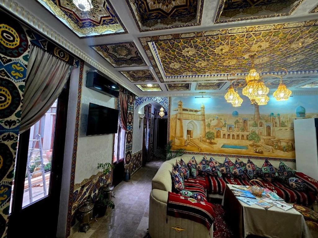 a room with chairs and a painting on the wall at Gulnaraxanum Boutique Hotel Premium in Bukhara