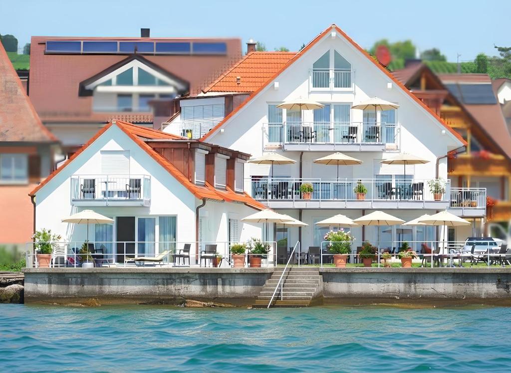 a large white building on the water near the water at Seehotel BelRiva in Hagnau