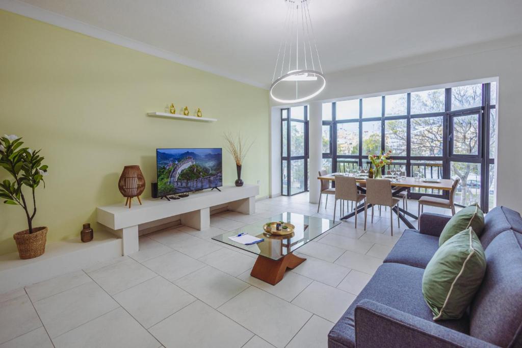 a living room with a blue couch and a table at Spacious 3BR Retreat Overlooking Marina in Msida
