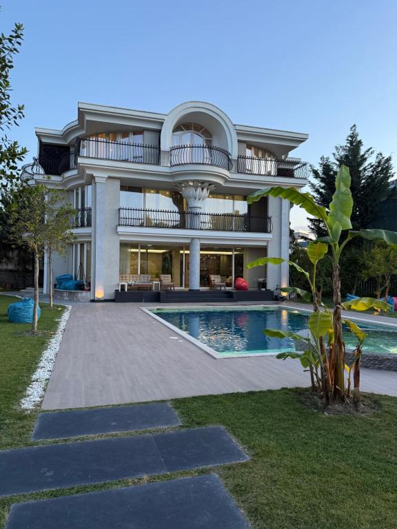 a large house with a swimming pool in front of it at Villa Florence in Tirana