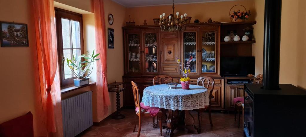 a dining room with a table with chairs and a cabinet at Respiro di montagna by Lago Maggiore Rentals in Vigino