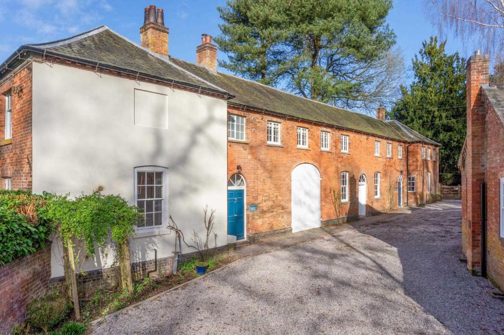 an old red brick building with a blue door at The Coach House in Barlestone
