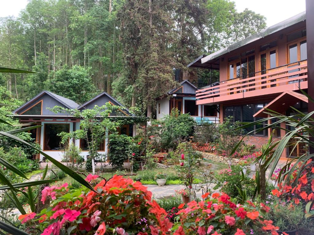 a garden in front of a house with flowers at Ngan Nga Legend in Bắc Hà