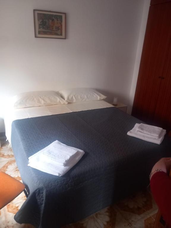 a bedroom with a blue bed with two towels on it at Casa Maria Naxos in Giardini Naxos