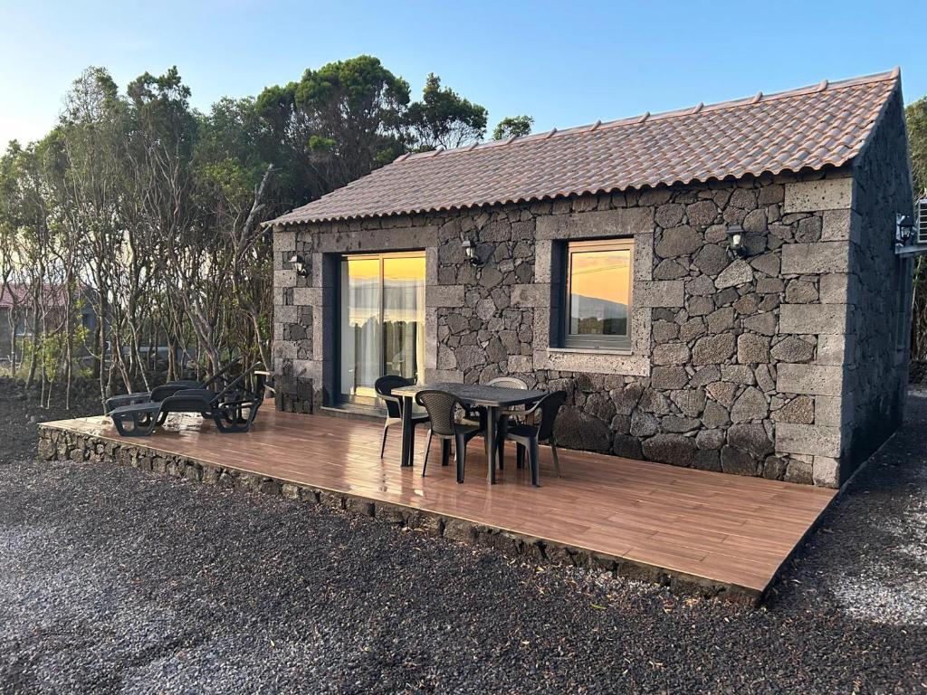 a house with a wooden deck with chairs and a table at AL Adega do Calcetas in Cais do Mourato