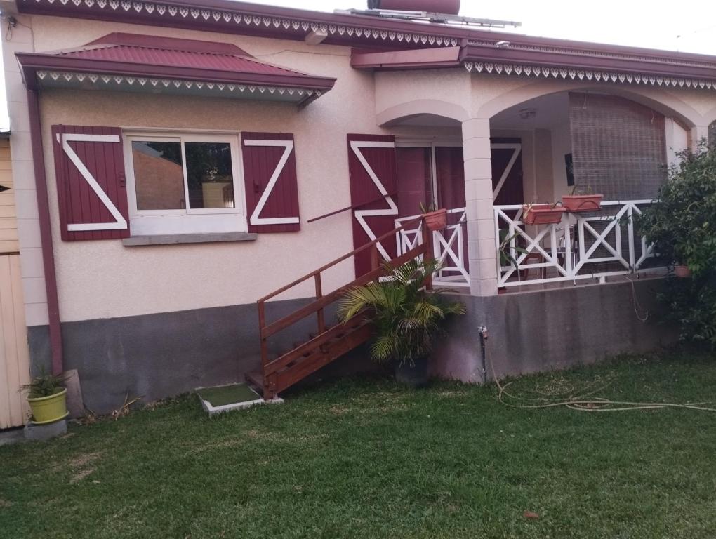 a house with a porch and a deck at Appartement 974 in Le Tampon