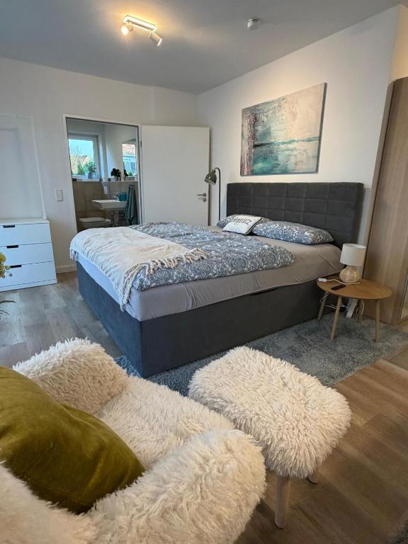 a bedroom with a large bed and a chair at Smart-Stay Bielefeld in Bielefeld