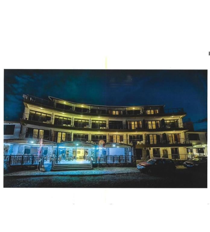 a building with lights in front of it at night at Hotel VICTORY in Vama Veche