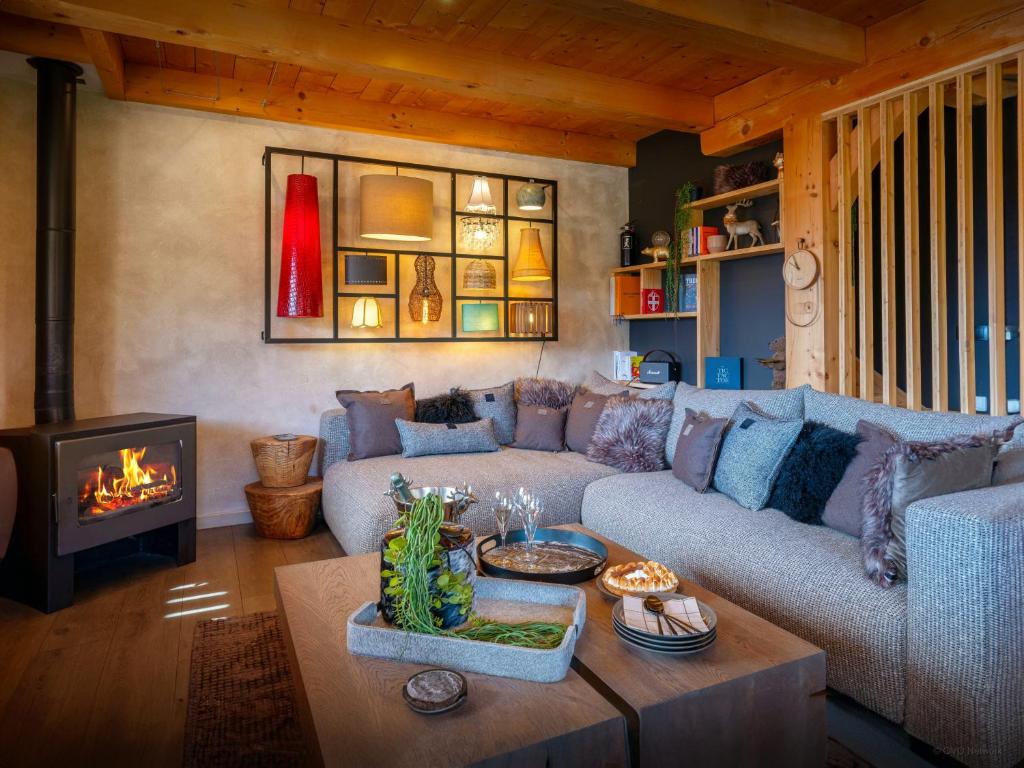 a living room with a couch and a fireplace at Chalet Sivara - OVO Network in Manigod