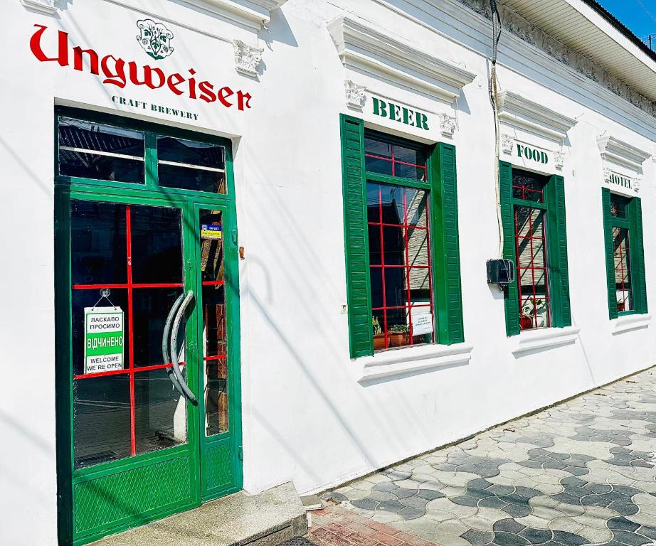 a store with green doors and windows on a street at Ungweiser in Uzhhorod