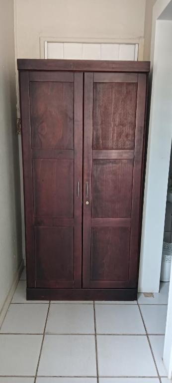 a wooden cabinet with two doors in a room at Meltz Inn in Klerksdorp