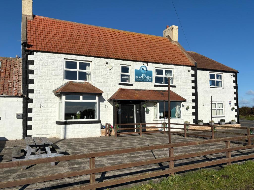 a building with a wooden deck in front of it at The Island View B&B - A1 in Berwick-Upon-Tweed