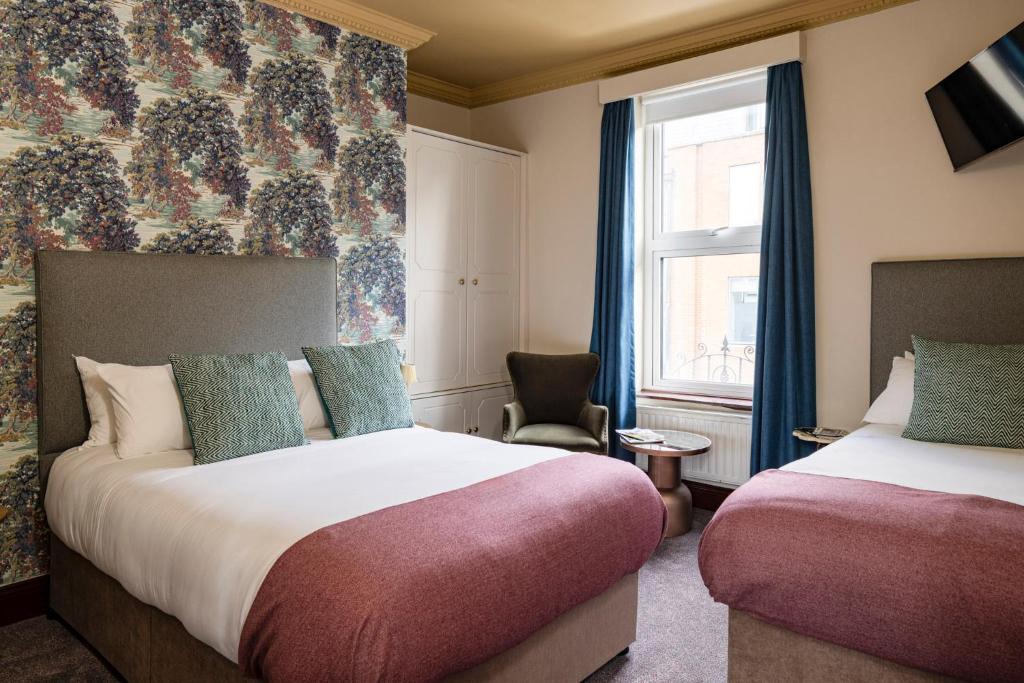 a hotel room with two beds and a window at O'Donoghue's in Dublin