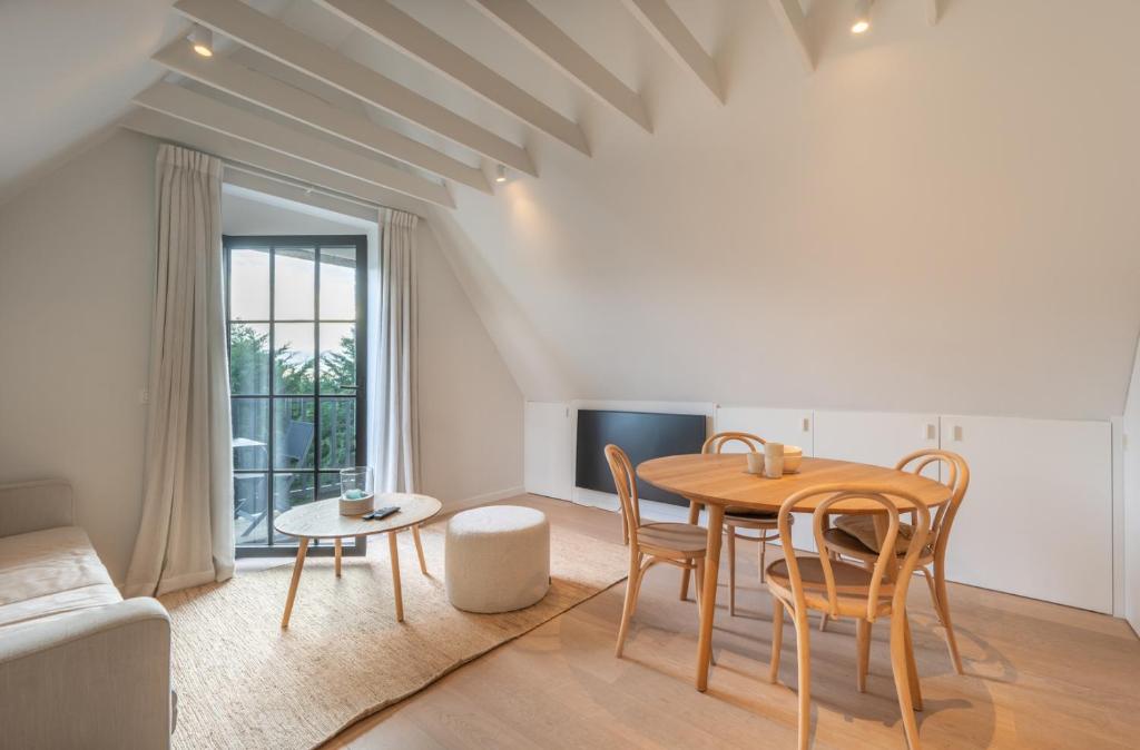 a living room with a table and chairs and a couch at Calm, Light-Filled Apartment with Private Balcony in Knokke-Heist