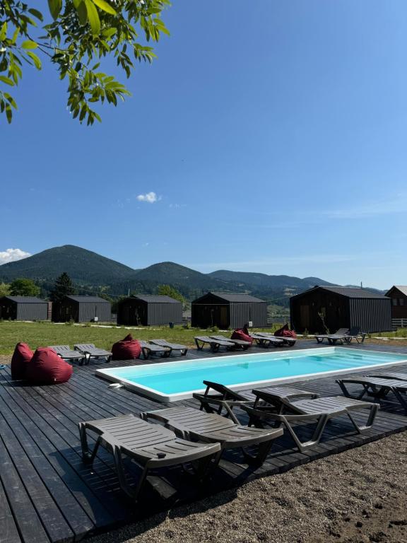 a swimming pool with chaise lounges and lounge chairs at Красник Хілс in Krasnik