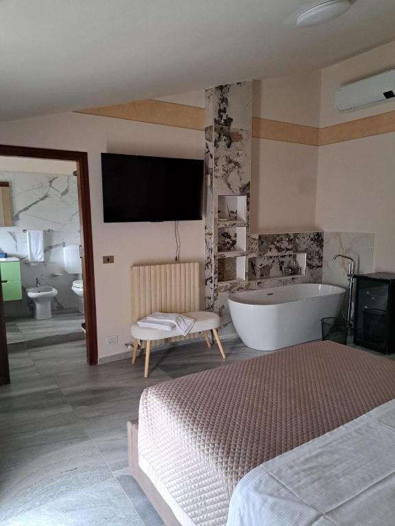 a large bathroom with a tub and a tv on the wall at Hotel-Ristorante KerMes in Boccaleone