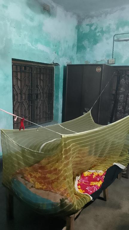 a hammock in a room next to a wall at o ARYABHATTA o in Bāndel