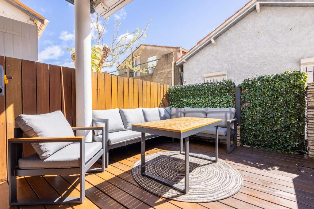 a patio with a table and chairs on a deck at La Maison de lOrb in Valras-Plage
