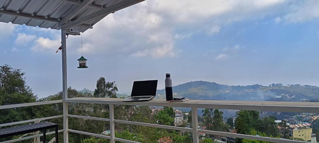 a laptop sitting on a table on top of a balcony at Smiley Homestay Family-Friendly 3BR in Kodaikānāl