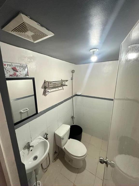 a bathroom with a toilet and a sink at Retro Themed Condominium Staycation in Marilao