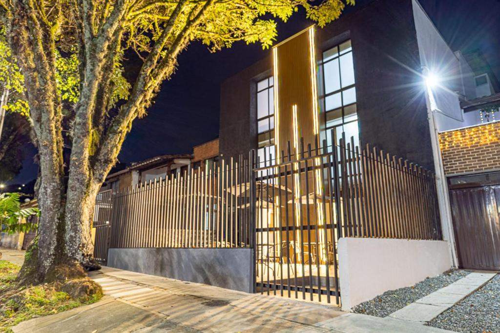 a fence in front of a house at night at Hotel Radix Living in Medellín