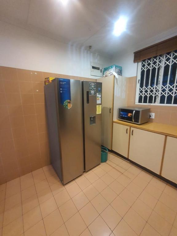 a kitchen with a stainless steel refrigerator and a microwave at Peaceful Corner Stay in Durban