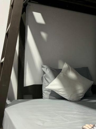 a bed with two white pillows on top of it at Surabaya Vibes Hostel in Surabaya