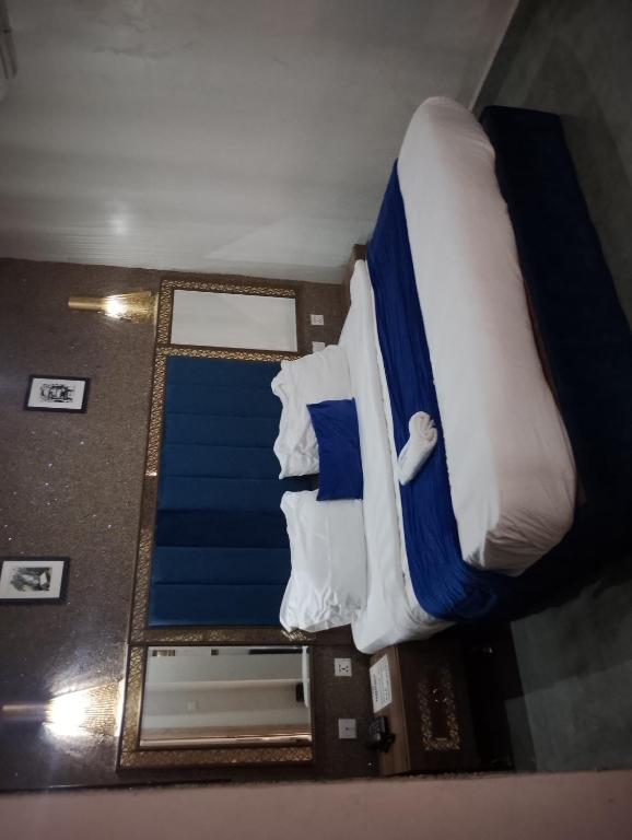a bedroom with two beds with blue and white sheets at Mar'maris Residence Hotel in Owerri